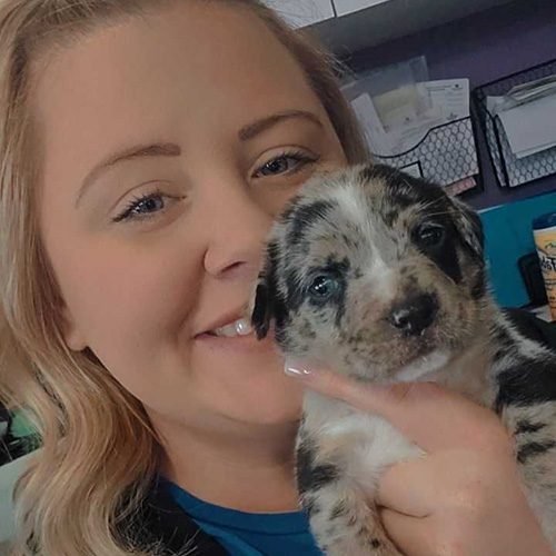 Haley McCarthy holding a small, spotted puppy